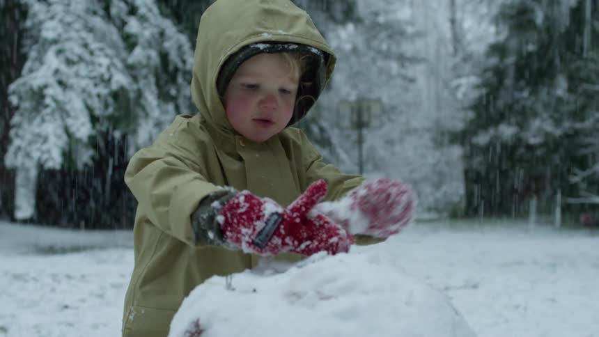 A child is building a snowman