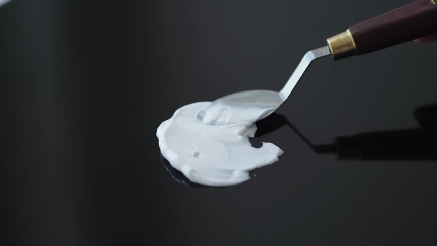 A beauty cream is spread across a reflective surface