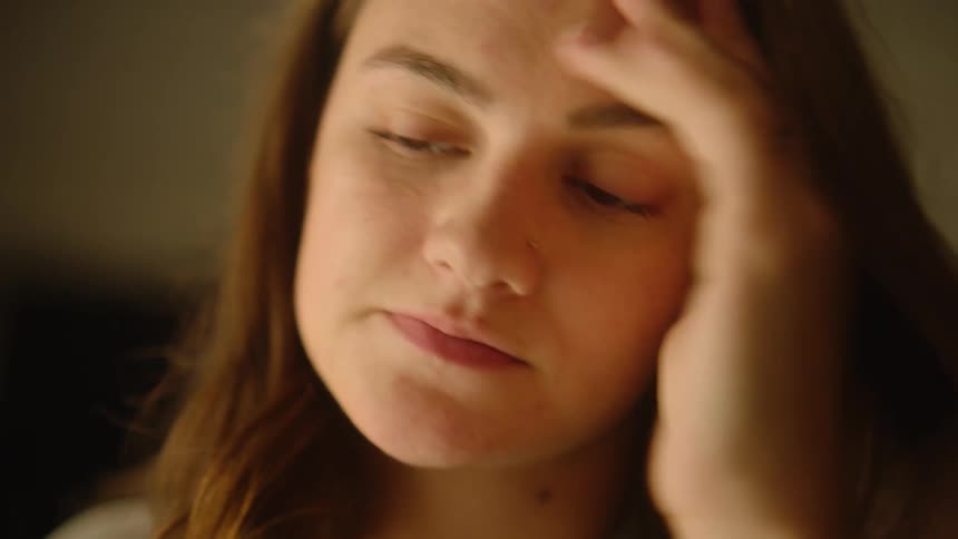 A woman looking frustrated and upset plunks her head down on her desk
