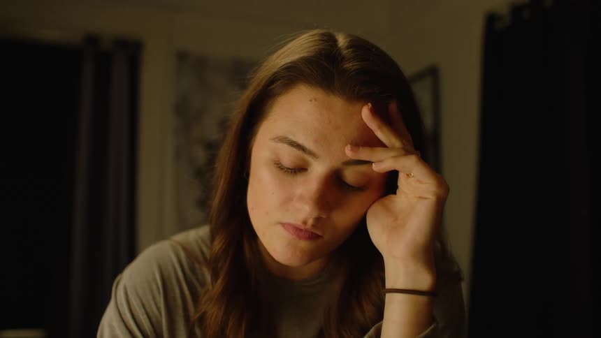 A woman places her head down on her desk
