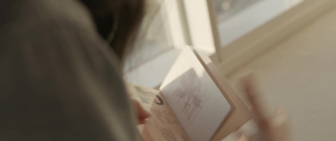 A woman picks up a passport and opens it