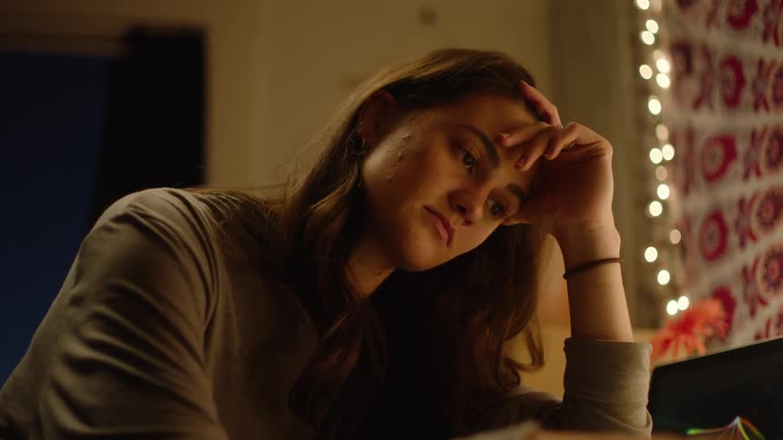 A girl falls asleep doing homework