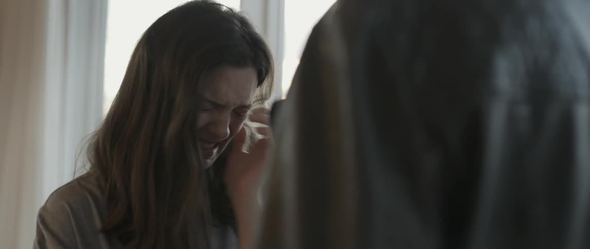 A woman is crying and talking to a person