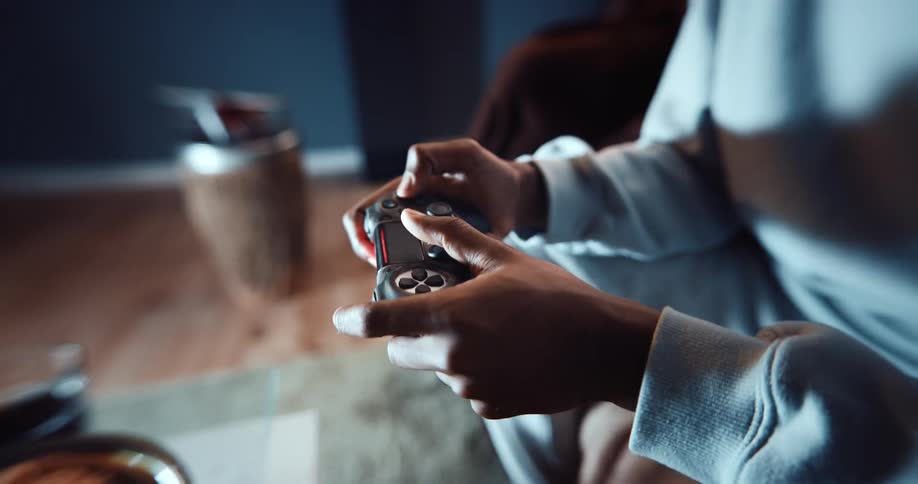 A woman is sitting in a chair in a home playing a video game