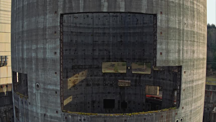 Aerial shot pulling back to show a shut down nuclear reactor tower
