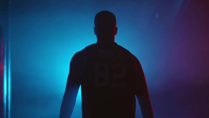 A man is walking in the dark toward a light in a room