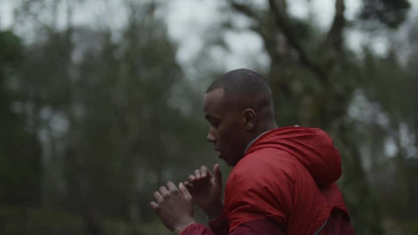A man in a forest runs and jumps