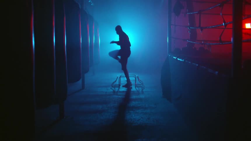 A man is in a gym exercising at night
