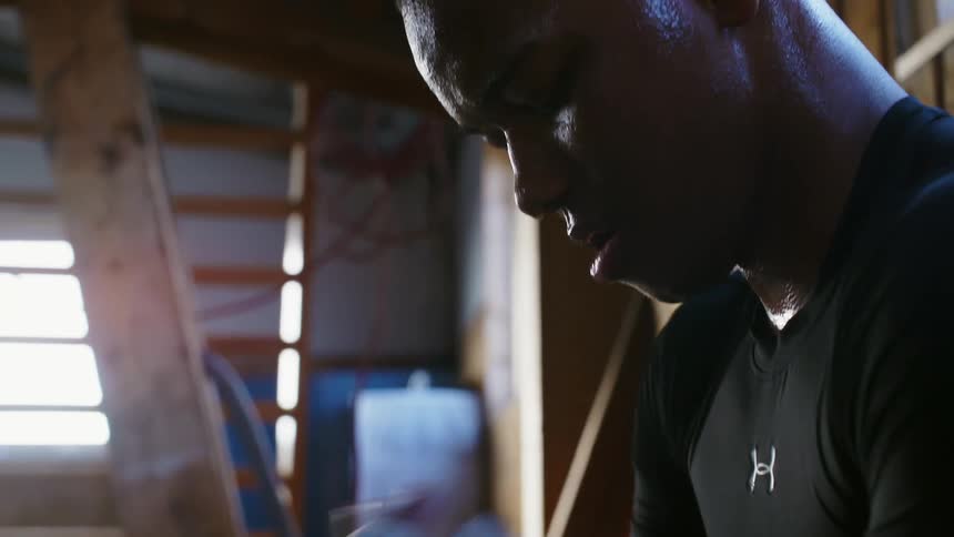 A man is sweating as he removes the tape form his hands