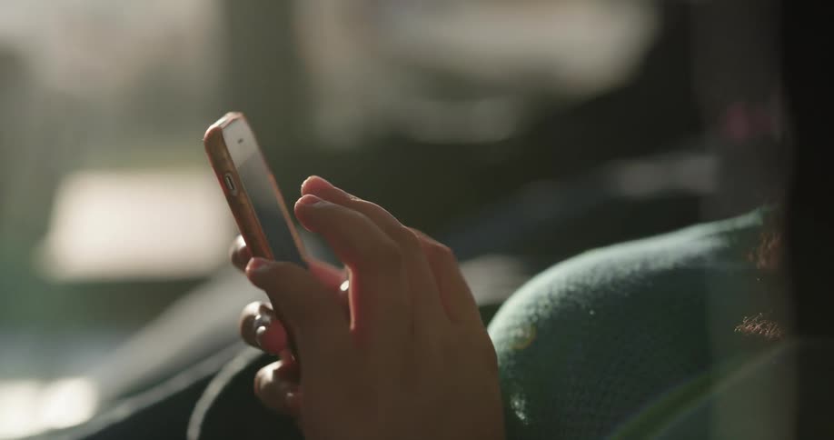Woman sits and briefly scrolls on mobile phone