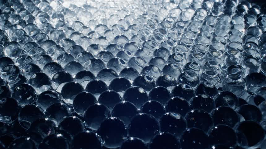 Clear globes in a grid fill and glow chasing away shadow