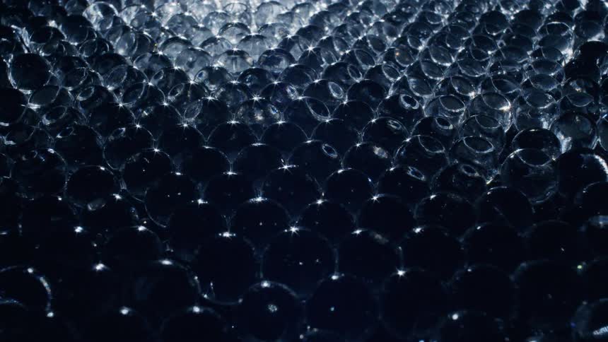 Light shines on a texture made of clear round objects