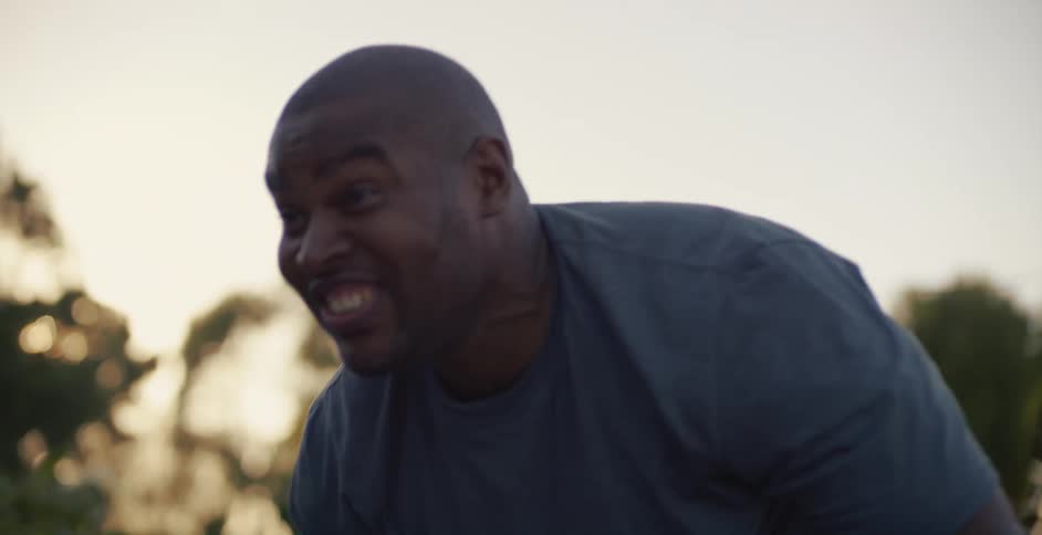 A man lets go and claps while teaching his daughter to ride a bike suddenly looks alarmed and runs