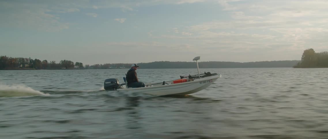 A man is speeding across achoppy lake in a boat
