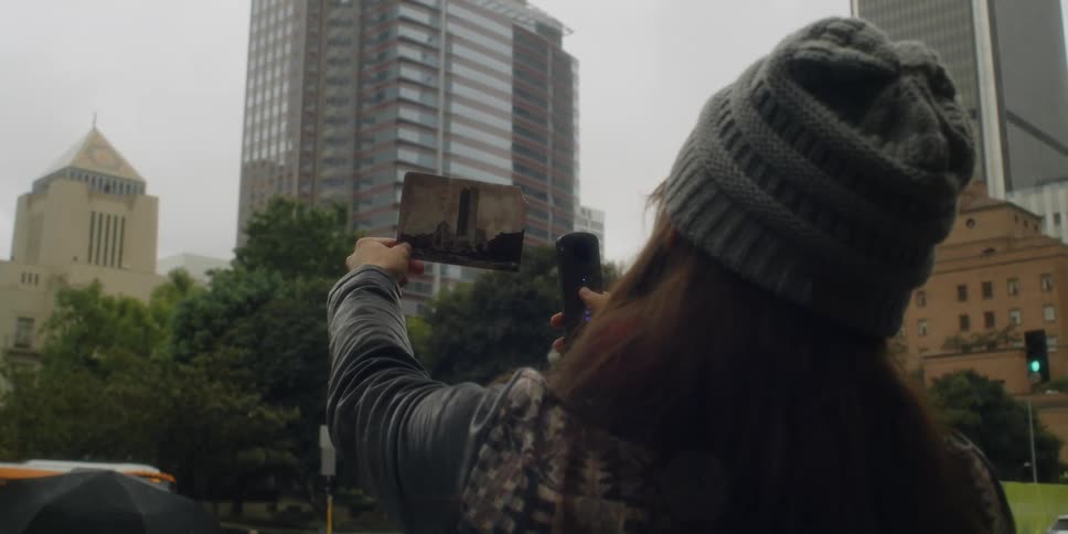A woman is standing outdoors in a downtown city during spring