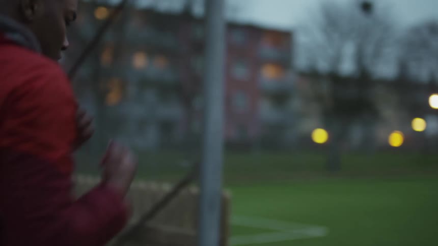 Man runs along sidewalk shadow boxing passing lit outdoor lights