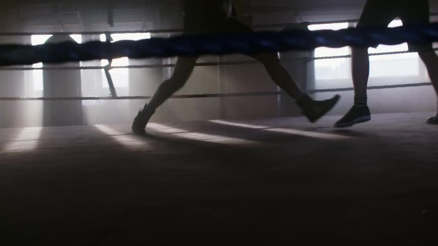 Two people box in a dark room