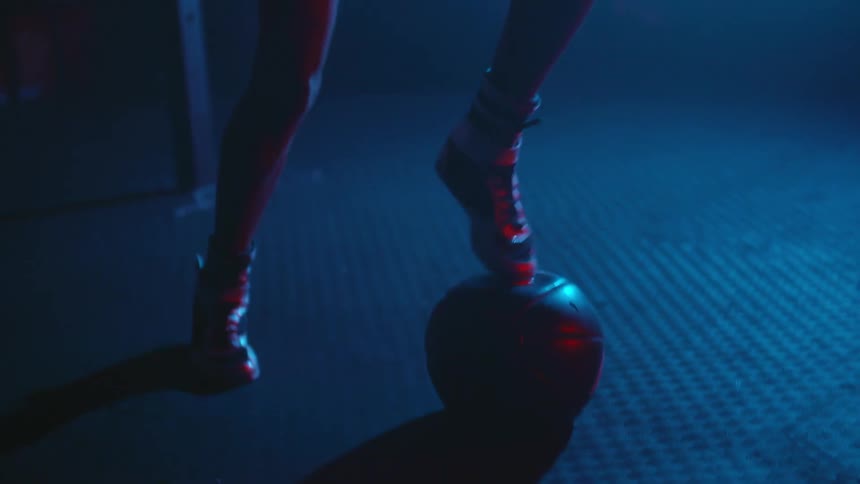 A man kicks the medicine ball in the gym