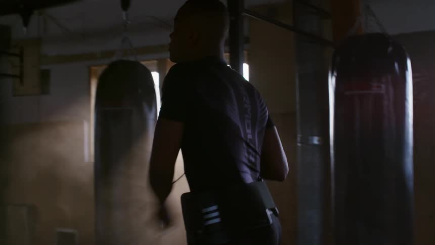 Male boxer jumps rope in hazy boxing gym