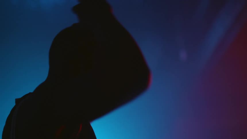 A man stretches in the dark gym