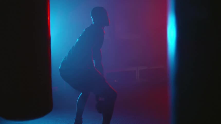 A man is in a gym swinging a kettle bell
