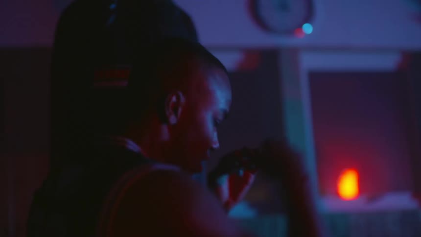 Male boxer shadowboxes in dimly lit boxing gym