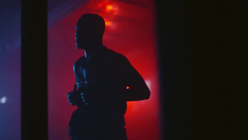 A man is in a dark room exercising