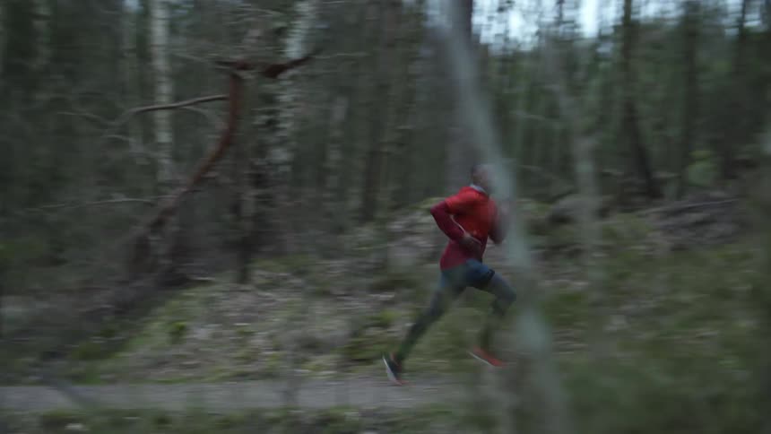 A man runs through the woods