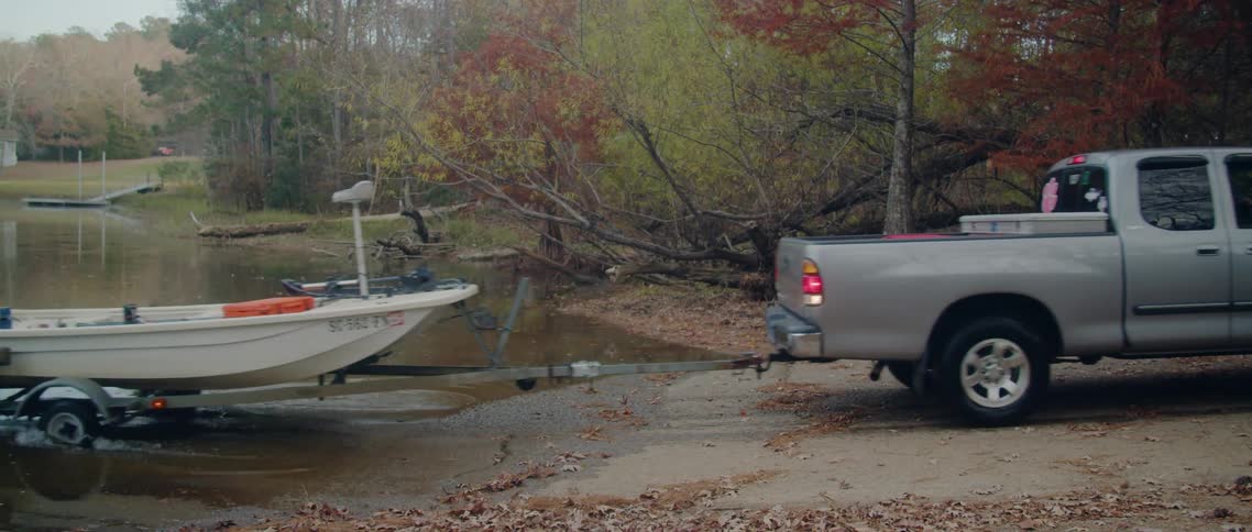 Man backs boat trailer and truck into water to launch boat