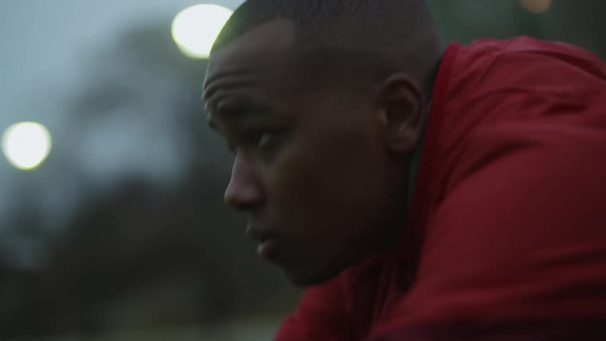 Man with red jacket works out in public park