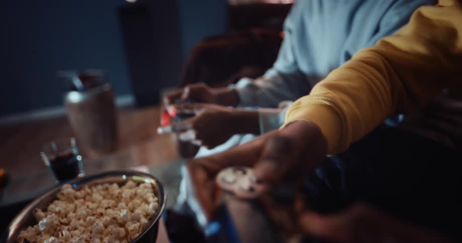 Men are sitting indoors and playing video games