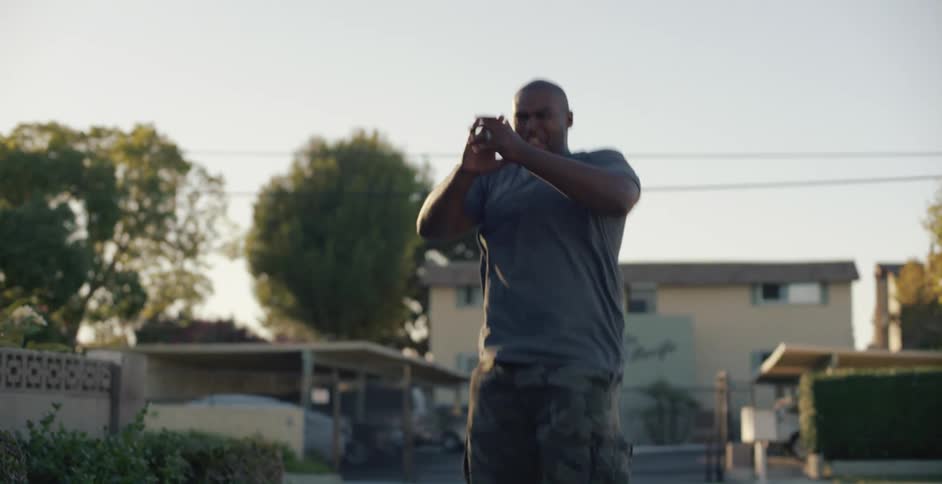 A man pushes his daughter on a bike and then jumps and claps as she rides away and suddenly goes running towards her with a worried look on his face