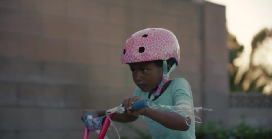 Father helping daughter learn to ride a bike