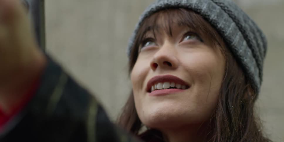Close up of the face of a happy woman holding a phone up