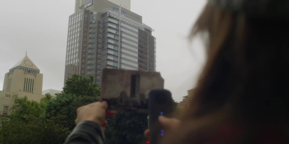 A woman holds a photo outside