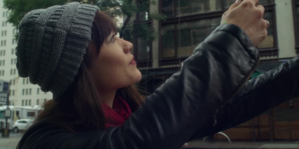 A woman taking a photo of a building