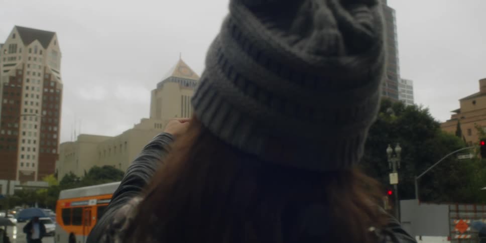 Woman uses a smartphone to take a picture of a vintage photograph of a building in the city