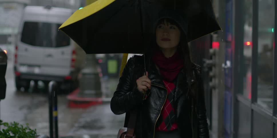 A woman walks in the rain holding an umbrella