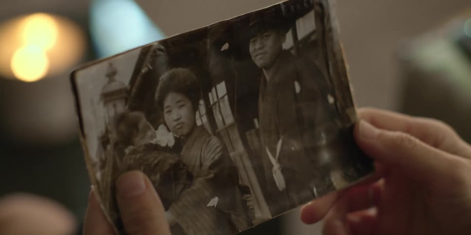Woman looks down at old photographs