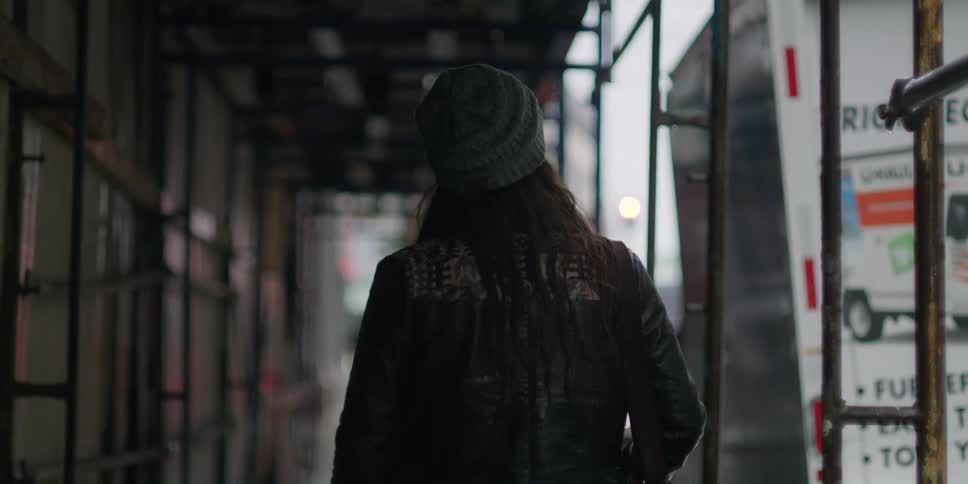 A woman walks under the scaffolding in the city