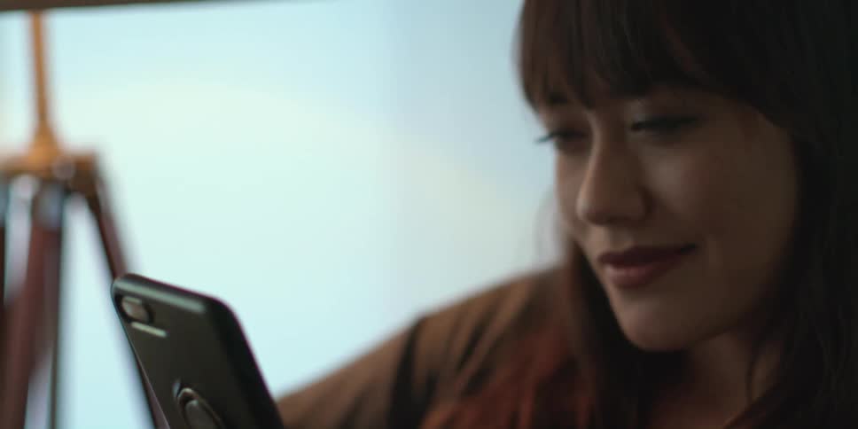 A woman is typing on her phone