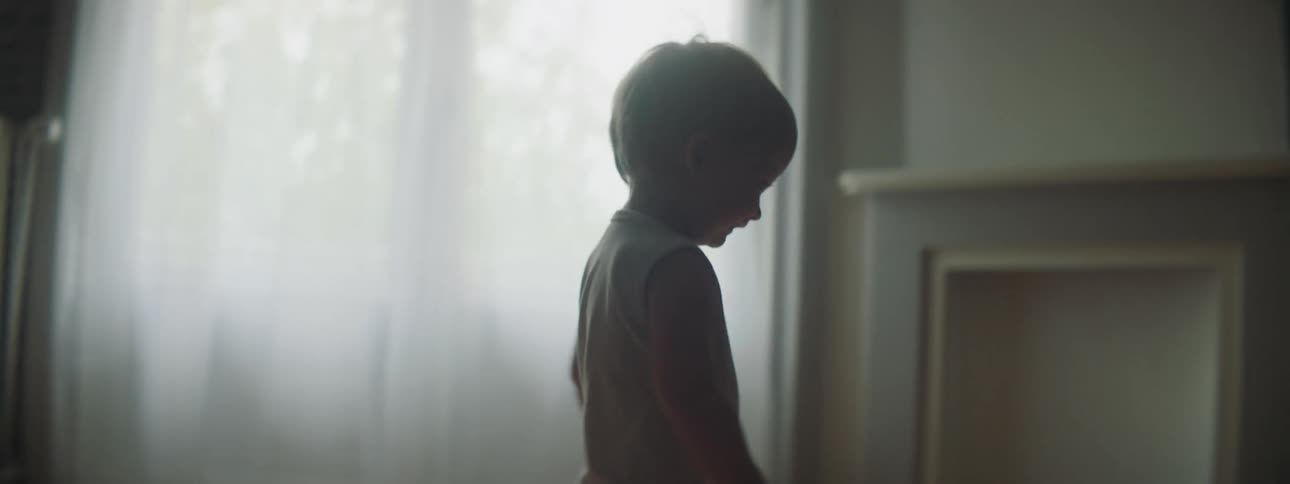 Toddler follows electric toy car across wooden floor