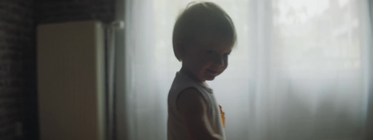 A child walks with toys in his hands