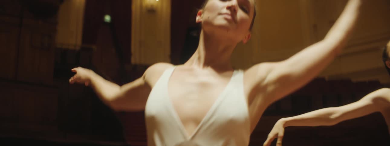 Two women dance together on stage