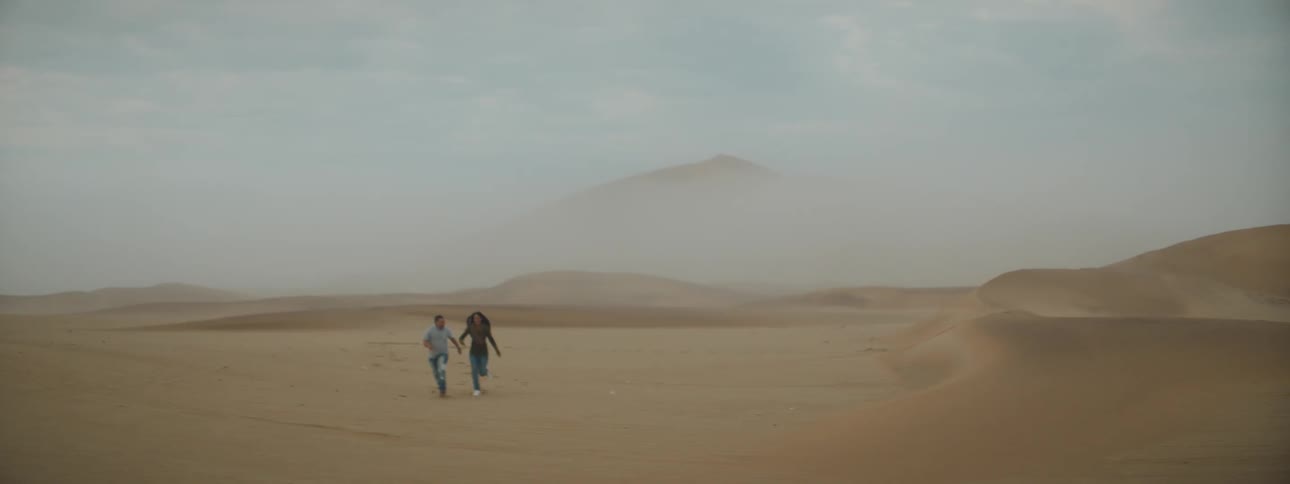 A man and woman are running in the desert