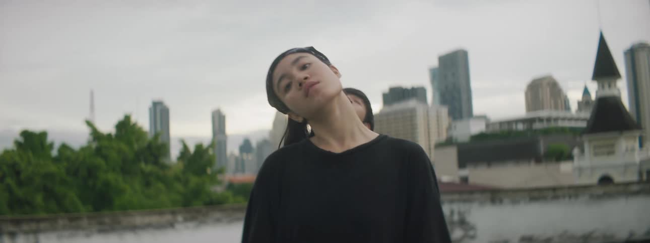 Two teenagers dancing in front of a city skyline