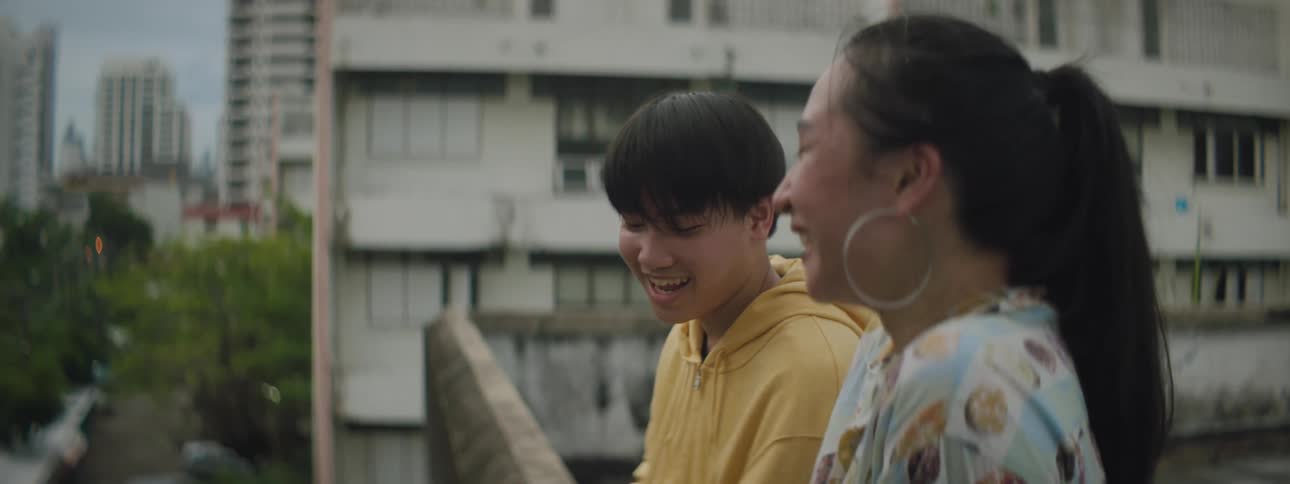 A man and woman sitting outside an apartment building talking