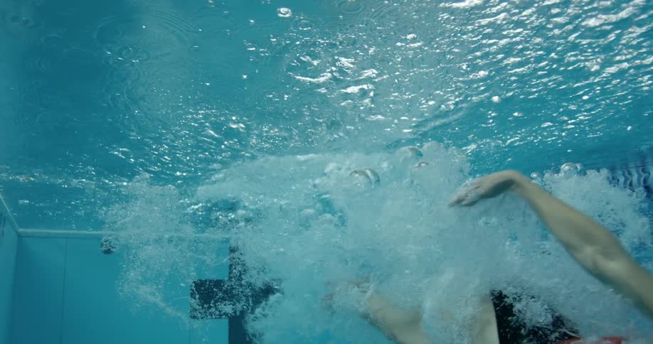 A woman dives into a pool