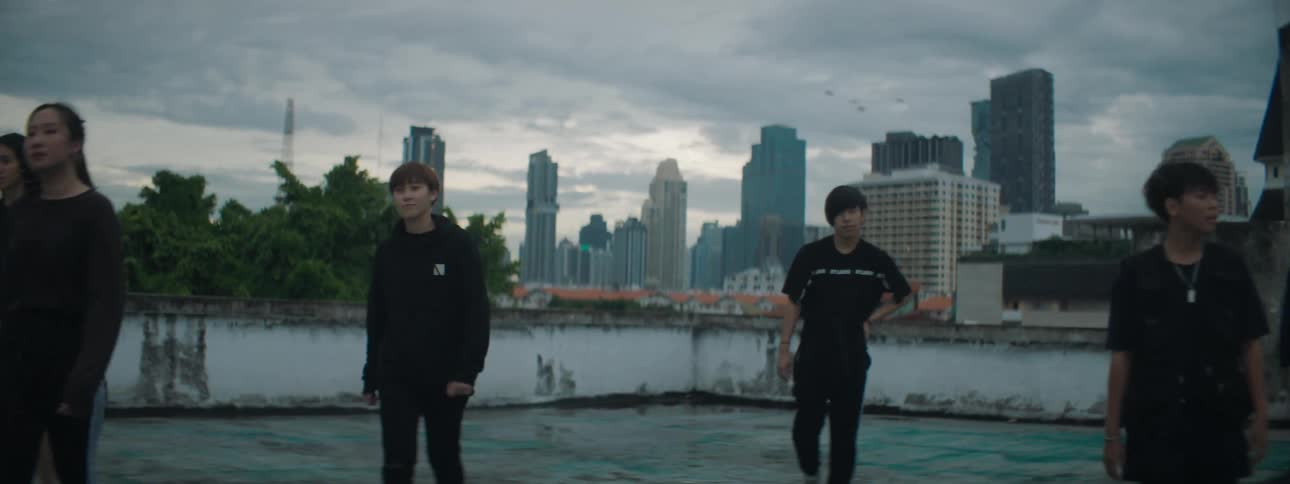 A group of teenagers walk across a roof top