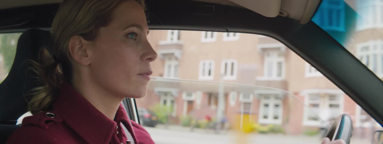 A woman driving in her car down a street